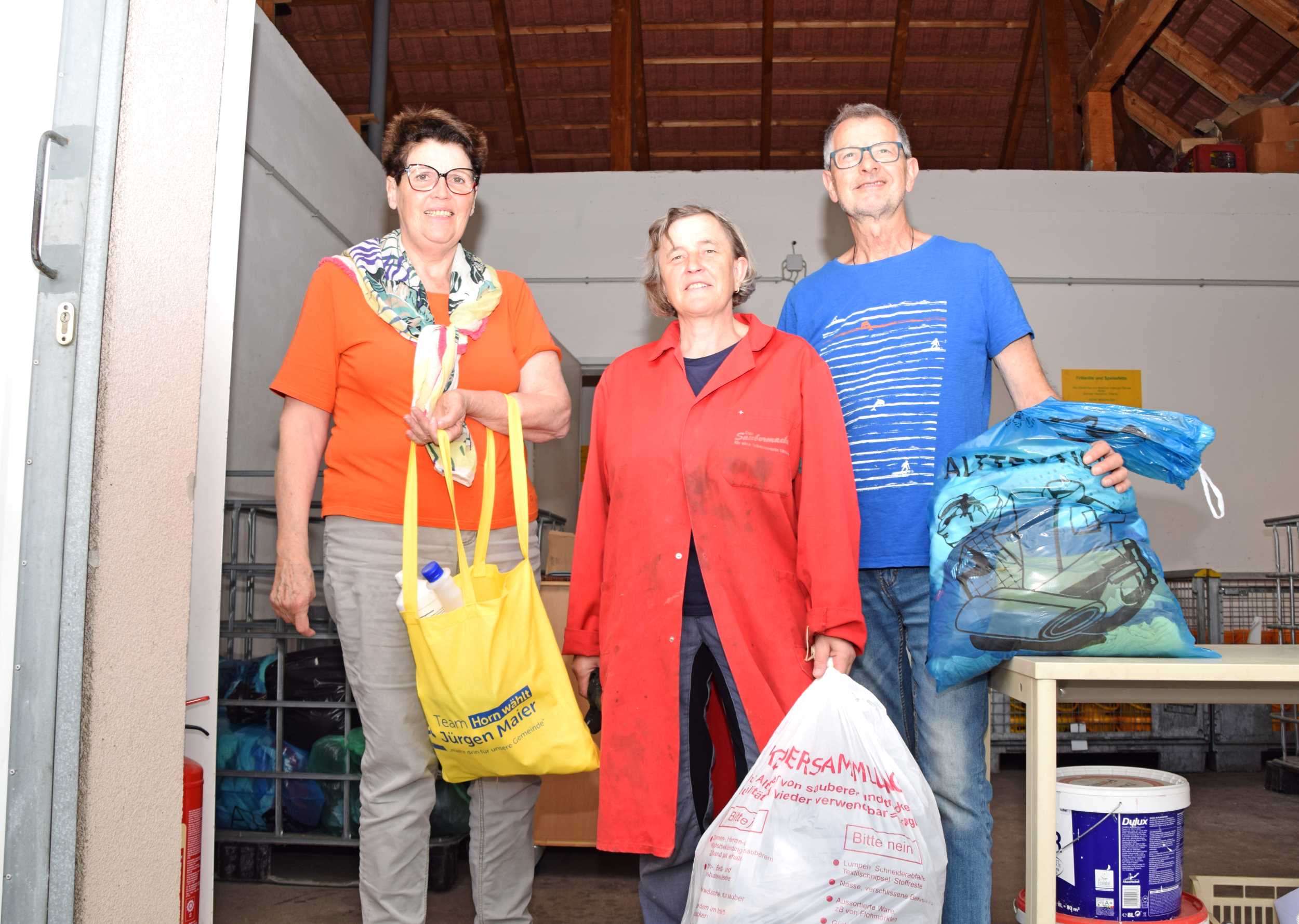 Frau Maria Gerstorfer (l.) bringt dem Bauhof abgelaufene Medikamente und Putzmittel und Herr Erich Kornberger (r.) gibt Altkleidung an Frau Rosemarie Zirngast (mitte) ab. Foto: Gabriele Hohenegger 